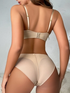 Rear view of nude seamless bra with thin straps and sheer striped mesh high waist panties