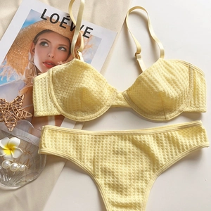 Detail of bright yellow lace lingerie set with adjustable straps on a stylish magazine
