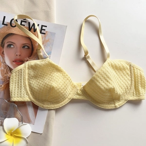 Detail of light yellow waffle lace bra with underwire and adjustable straps for women