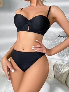 Close-up of black seamless lingerie set with cutout metal ring and matte fabric detail
