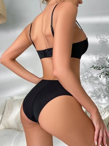Rear view of seamless black lingerie set featuring a soft bra and high-cut panties