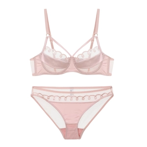 Vue à plat d'un ensemble lingerie en résille rose clair avec dentelle et satin