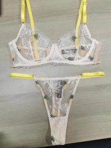 Vue détaillée d'un ensemble de lingerie en dentelle blanche avec broderies d'ananas jaunes