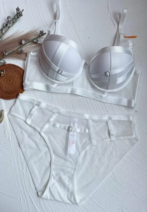 Flat lay view of a white lace lingerie set with cross-strap details and sheer mesh panels