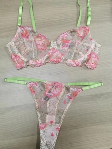 Détail de l'ensemble de lingerie en dentelle vert clair avec broderie florale rose et résille