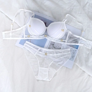 Détail d'un ensemble lingerie blanc avec anneaux métalliques dorés et empiècements mesh