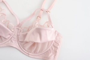 Detailansicht von rosa Satin-BH mit feiner Stickerei und goldenen Verstellern