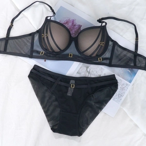 Détails d'un ensemble lingerie en résille noire avec anneaux dorés et bonnets rayés