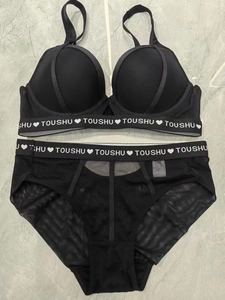 Détail d'un ensemble de lingerie noire avec des bandes élastiques blanches lettrées TOUSHU