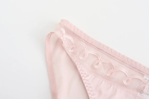 Détail de culotte en résille rose avec broderies élégantes et texture en satin soyeux
