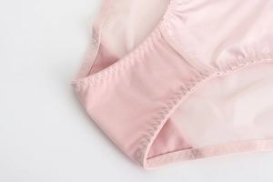 Détail du tissu en maille rose clair et des coutures délicates sur lingerie pour femmes