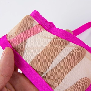 Détail du tissu en maille transparente avec bordure en satin rose vif et texture légère