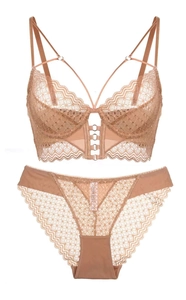 Detail of nude lace lingerie set with cross straps and floral embroidery on bra and panties