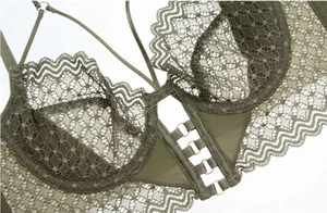 Detailed macro of dark green lace bra featuring metal ring and intricate lace textures