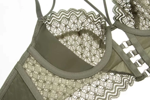 Close-up of olive green lace lingerie featuring scalloped edges and metal buckle details