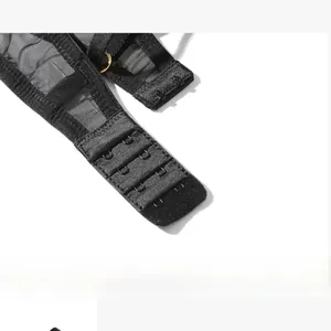 Détail de la fermeture à crochets du soutien-gorge en maille noire avec boucles dorées