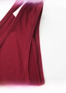 Detailed close-up of dark red cotton fabric featuring professional zigzag stitching