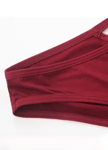 Detail of the high-elastic waistband and fine stitching on burgundy cotton panties