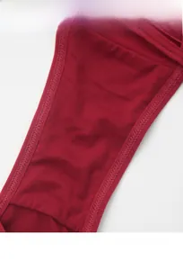 Detail view of cotton crotch area on dark red lace panties showing breathable texture