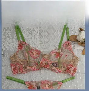 Détail d'un soutien-gorge en dentelle transparente avec broderie florale rose et bretelles
