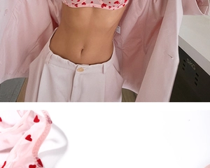 Détail d'un soutien-gorge en maille rose avec flocage cœur rouge et texture de tissu fin