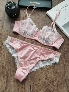 Ensemble lingerie en dentelle rose avec soutien-gorge à armatures et culotte sur bois