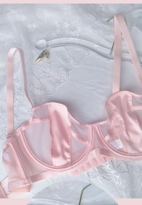 Detailed close-up of light pink satin and mesh lingerie set with a supportive underwire bra