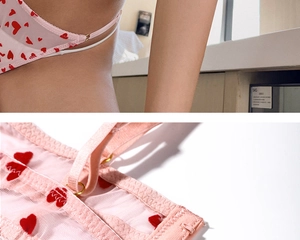 Détail d'un ensemble de lingerie en résille rose avec motifs de cœurs floqués rouges