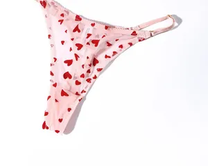 Détail du string en résille rose avec motifs de cœurs rouges et anneaux en métal