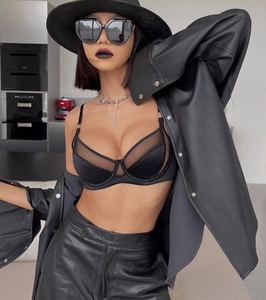 Gros plan d'un soutien-gorge en maille noire avec veste en cuir et chapeau élégant