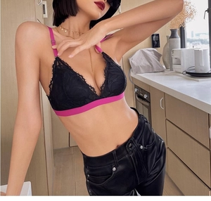 Detail of black lace triangle bra with vibrant pink straps and elastic underband