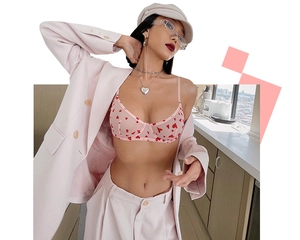 Détail d'un soutien-gorge rose transparent à cœurs rouges porté sous un tailleur rose