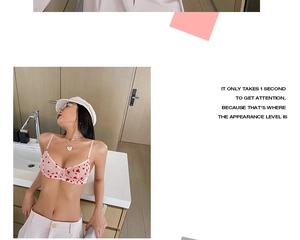 Détail d'un soutien-gorge en dentelle rose transparente avec motifs de cœur rouge