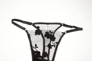 Detailed view of black floral lace embroidery and sheer mesh on sexy thong lingerie