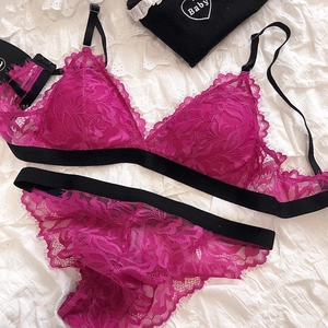 Detailed flat lay of rose red lace triangle bra and matching panties with black straps