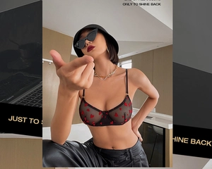 Détail d'un ensemble de lingerie en mesh noir transparent à broderie cœur rouge