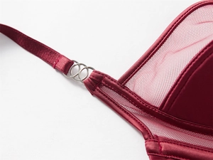 Gros plan détaillé des anneaux argentés reliant le satin et le mesh sur un soutien-gorge bordeaux
