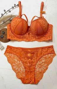 Detail of orange lace lingerie set with floral embroidery and criss-cross straps