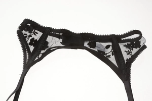 Detail shot of black floral lace garter belt with sheer mesh fabric and adjustable strap