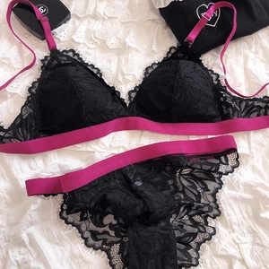 Detail of floral eyelash lace lingerie set in black with vibrant pink elastic bands