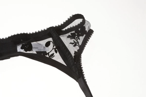 Detailed close-up of black lace mesh floral embroidery with scalloped edges and M size tag