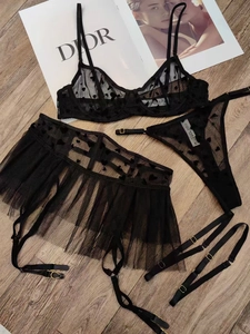 Détail d'un ensemble de lingerie en dentelle noire à motifs cœurs et boucles dorées chic