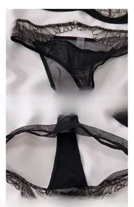 Détail de la broderie en dentelle florale noire sur un string en mesh transparent