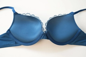Detail of dark blue lace bra featuring smooth cups and adjustable straps for lift
