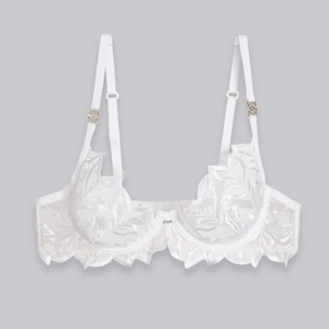 Detail of white mesh lace bra featuring elegant leaf embroidery and gold ring hardware