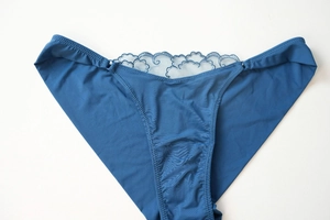 Detailed view of dark blue lace panties with premium fabric and intricate floral lace trim