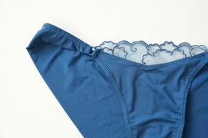 Detail of dark blue lingerie briefs featuring intricate lace edges and silky smooth fabric