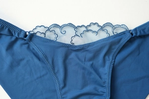 Close-up of deep blue lace embroidery and smooth fabric on the women's panties