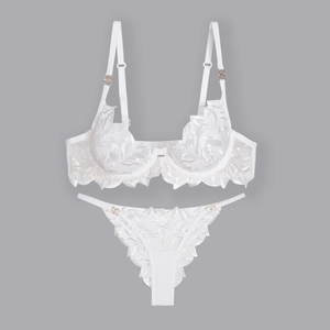 Detailed embroidery on white lace lingerie set with elegant gold metal ring fasteners
