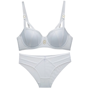 Detail of white mesh lingerie set with golden rings and criss-cross strap design